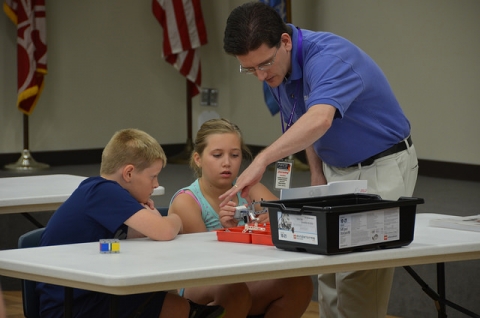Dos alumnes i un professor programant robots amb Lego
