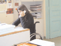 Noia en cadira de rodes treballant